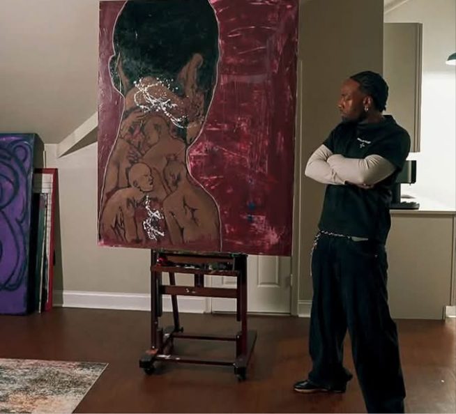 Willie Austin studying his painting of a figure seen from behind with smaller figures across its back, on deep red