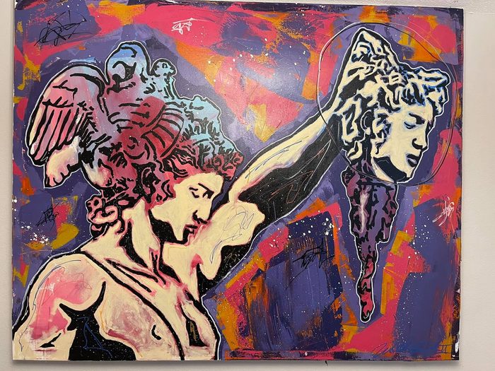 A classical figure in a winged helmet holding up a severed head, painted in pink, violet and orange