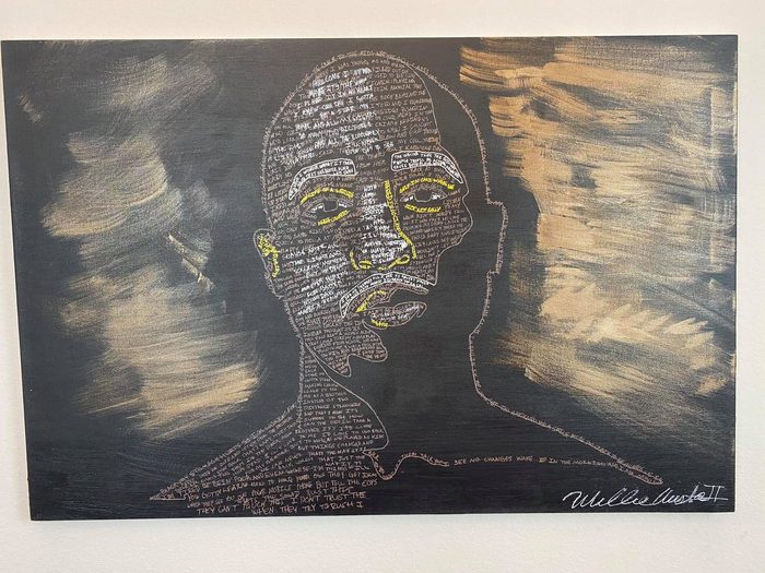Word portrait, a face outlined in white on black, filled with handwritten lyrics and framed by strokes of gold