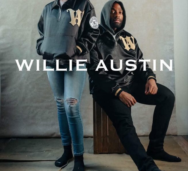 Two models in black Willie Austin Sideline Jackets, one seated, under the Willie Austin wordmark