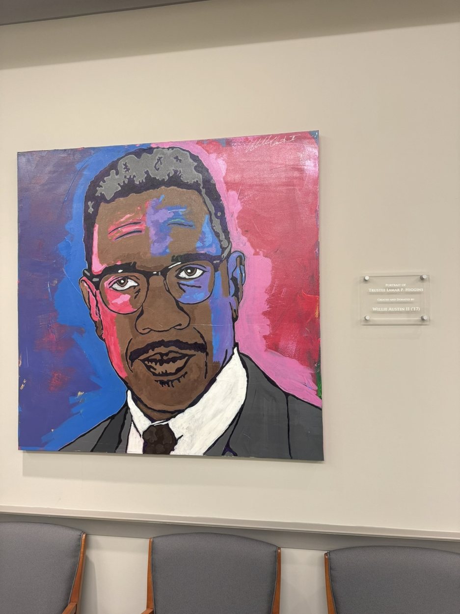 Willie Austin's portrait of Trustee Lamar P. Higgins hanging at the Rosa Parks Museum beside its plaque